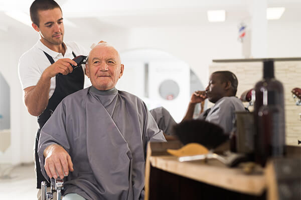Man getting hair trimmed by barber.