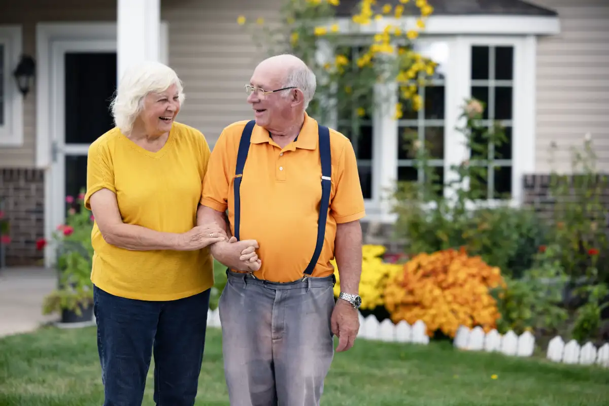 a couple walks in front of their home outside